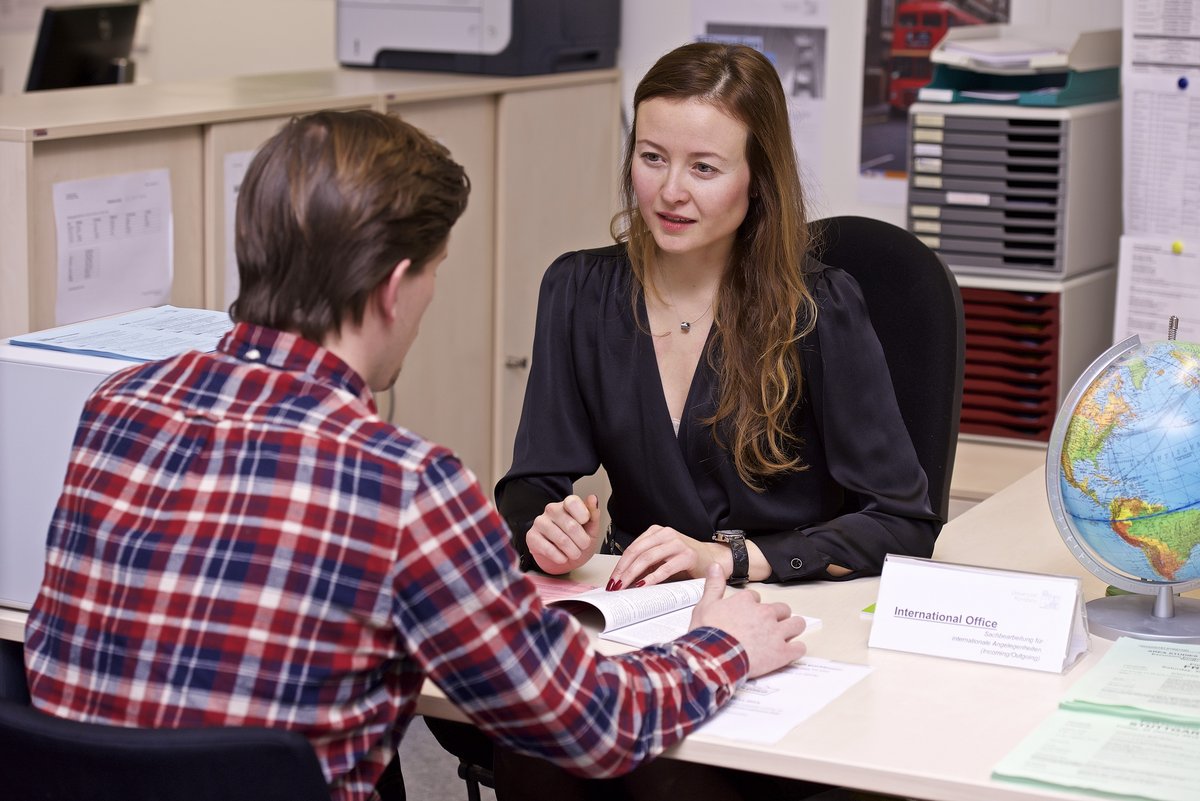 A student gets advice from a member of staff at the International Office table in the SSZ