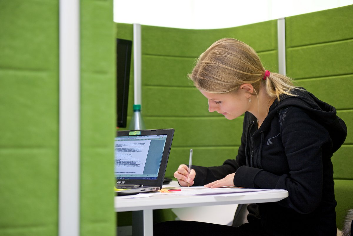 Studentin an einem Multimedia-Arbeitsplatz in der Bibliothek