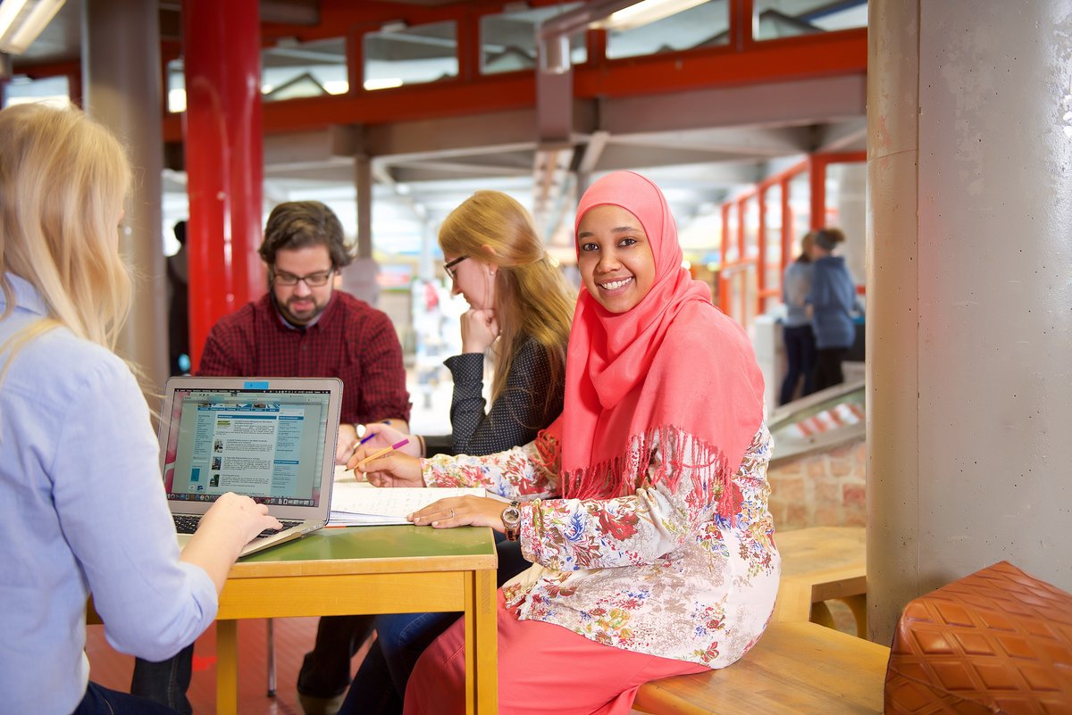 Studierende arbeiten und besprechen sich im Foyer